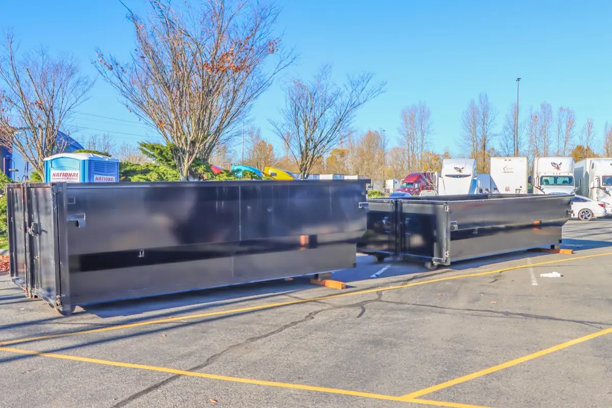 Professional dumpster rental service with roll-off container on residential driveway in East Highland Park